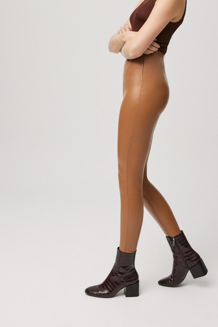 Leggings di tendenza Ysabel Mora modello 70164 effetto pelle in tessuto termico. Pantaloni internamente felpati, con pieghe nella parte anteriore e posteriore per sagomare la silhouette. Con caviglia a taglio vivo. Disponibile in nero e beige. 92% Poliestere, 8% Elastan