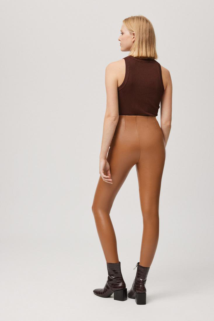 Leggings di tendenza Ysabel Mora modello 70164 effetto pelle in tessuto termico. Pantaloni internamente felpati, con pieghe nella parte anteriore e posteriore per sagomare la silhouette. Con caviglia a taglio vivo. Disponibile in nero e beige. 92% Poliestere, 8% Elastan