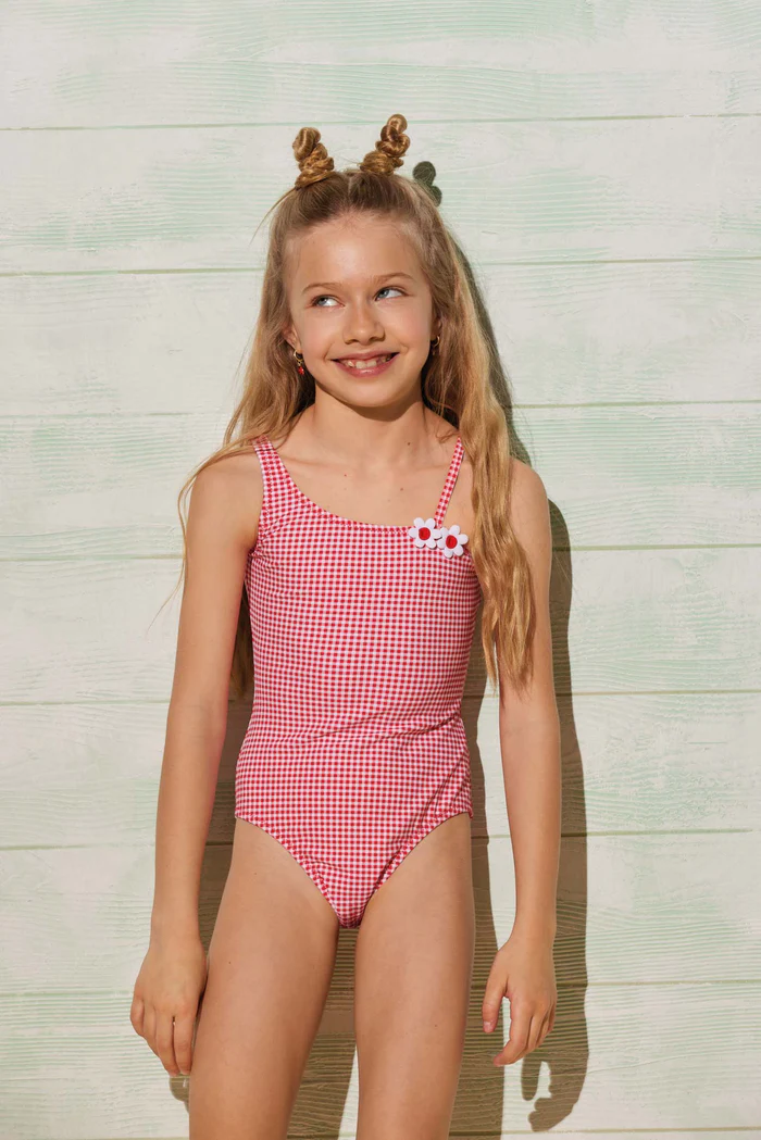 Collezione Sailor per bambini YSABEL MORA. Costume da bagno per bambini e ragazze con stampa a scacchi rossi e dettaglio. Cinghie asimmetriche.