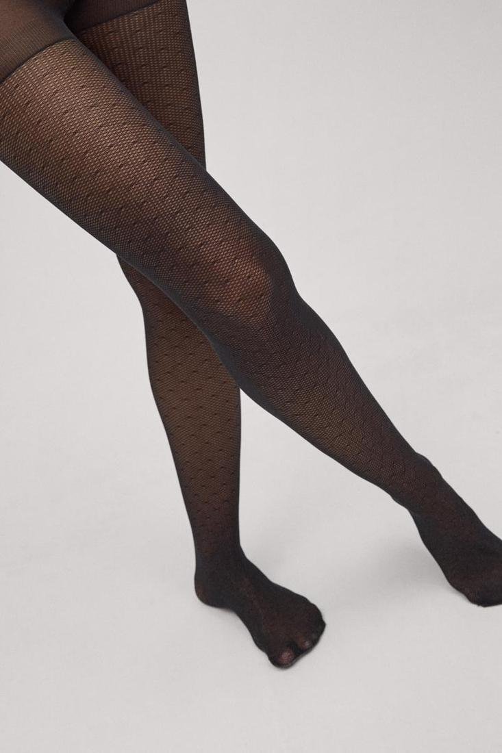 Collant Ysabel Mora 20 den in microgriglia con stampa a pois neri. Composizione:85% Poliammide, 15% Elastan.